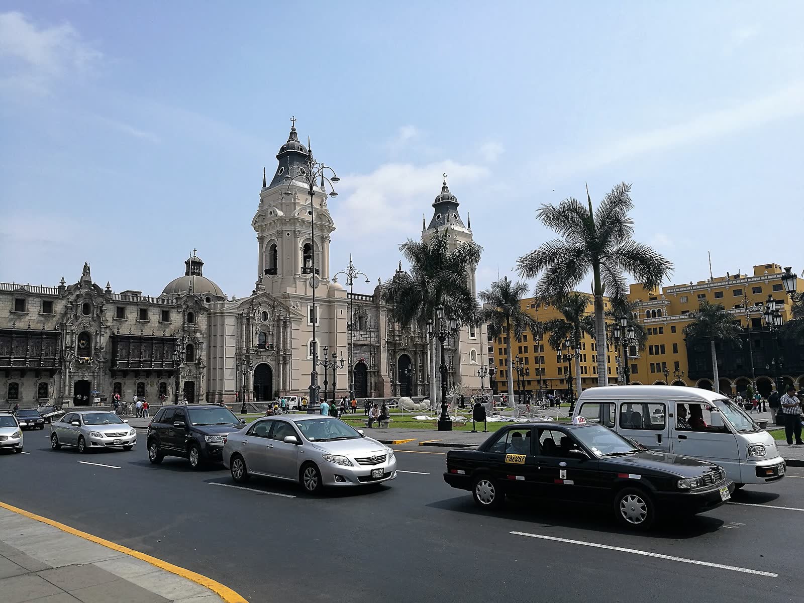 Catedral de Lima y Palacio Arzobispal en la Plaza Mayor, con palmeras y edificios amarillos